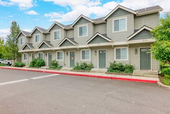 an apartment building with a red curb and a parking lot at Trillium Apartments, Springfield, OR, 97477
